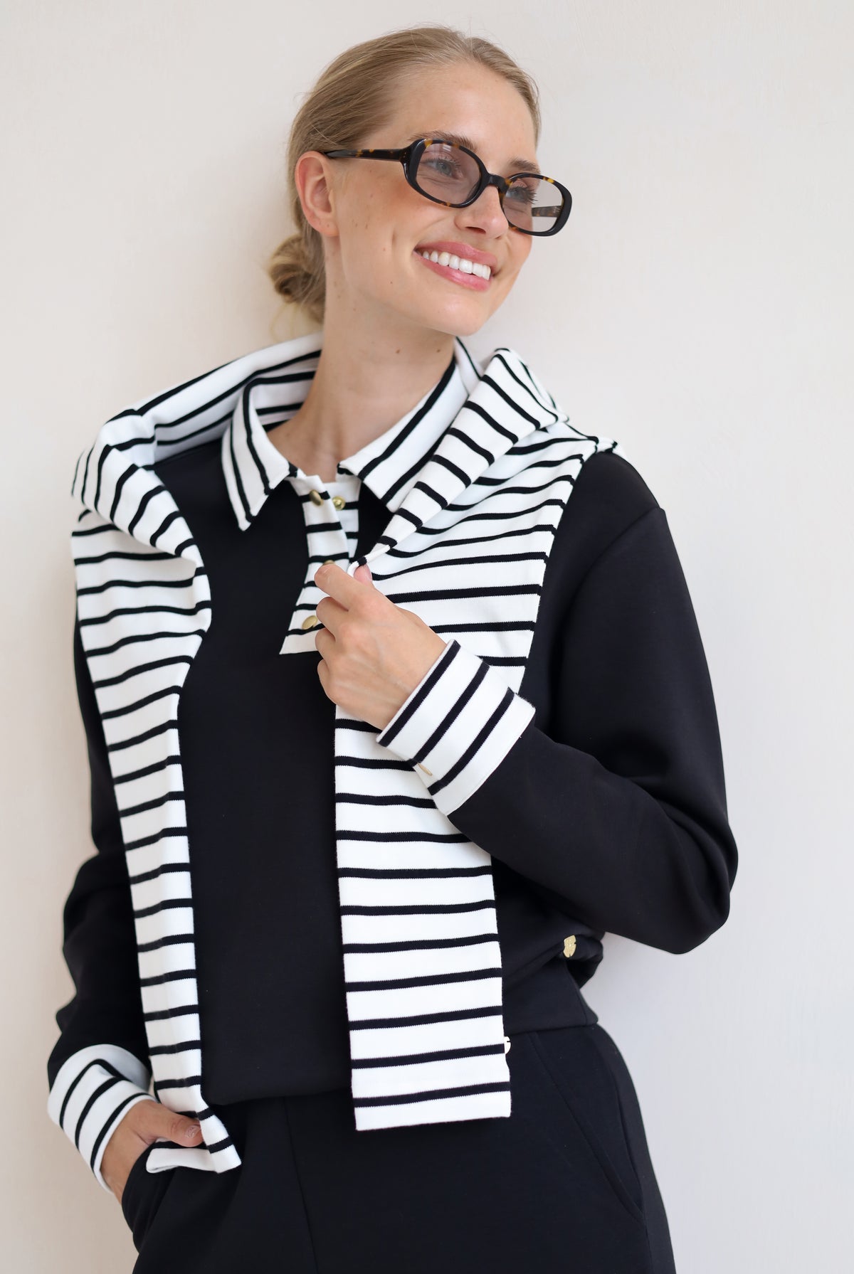 House of Gravity Button Polo Sweater in Black styled with a striped knit draped over the shoulders.