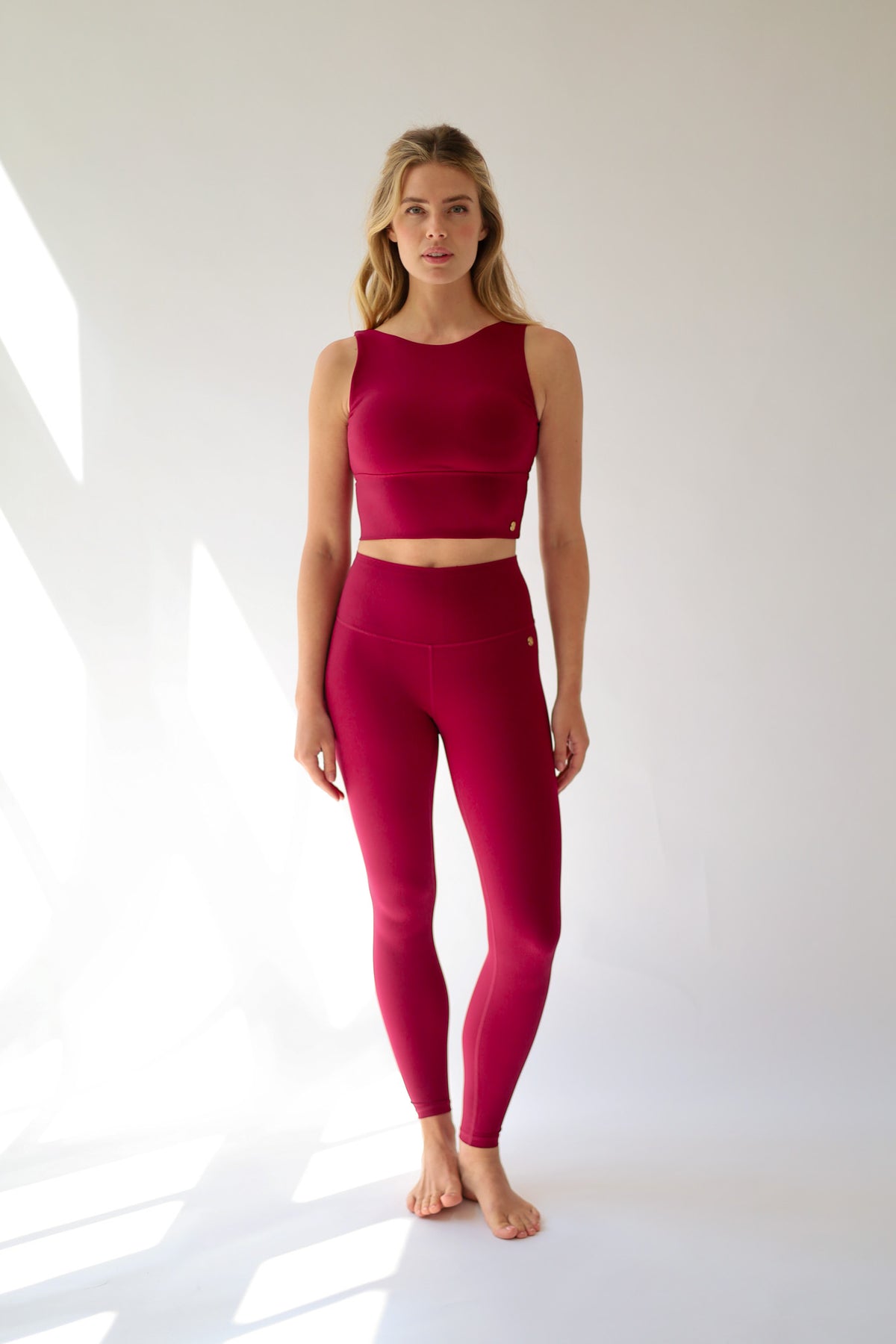 Woman wearing a red athletic outfit on a white background