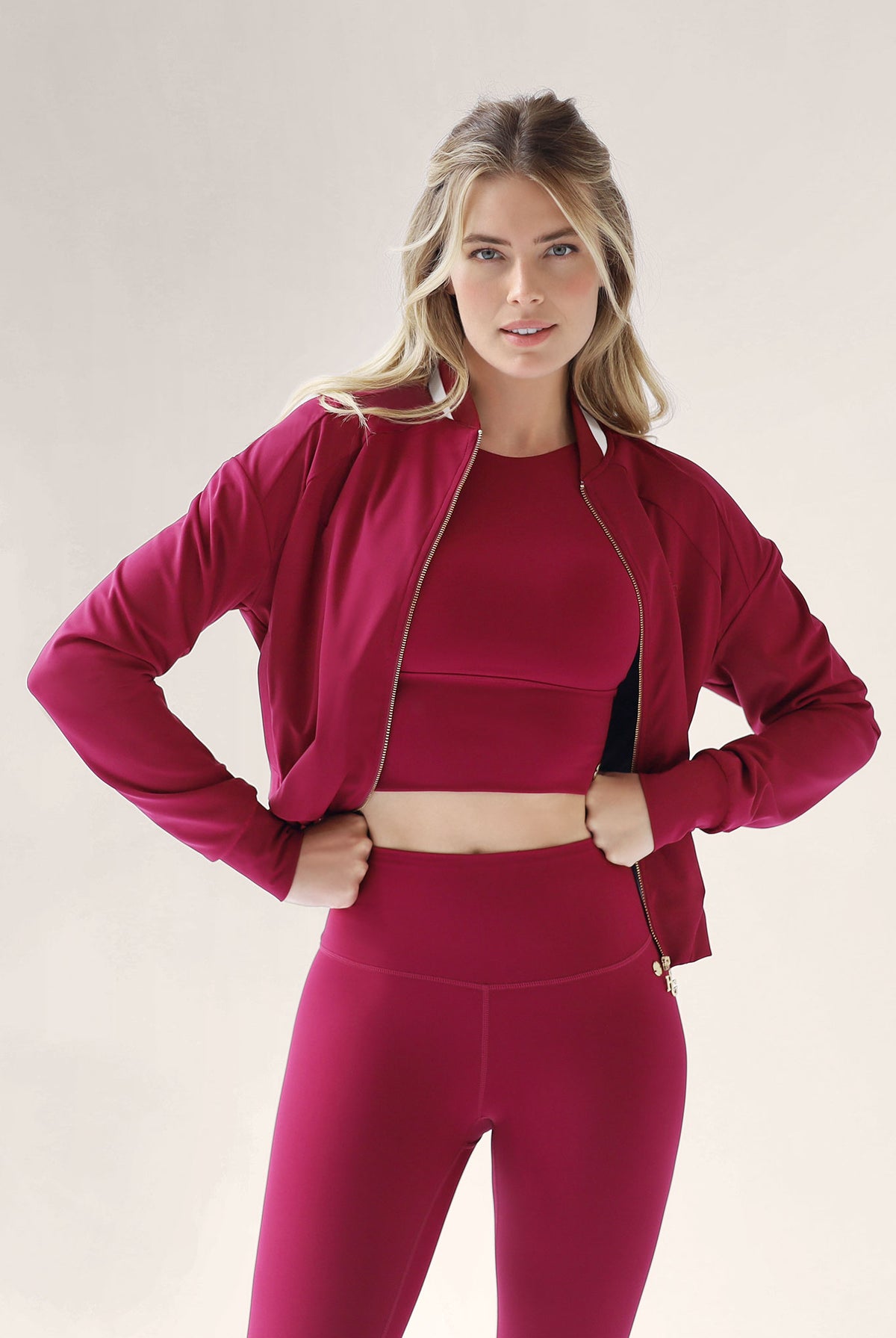 Woman wearing a red athletic outfit on a plain background