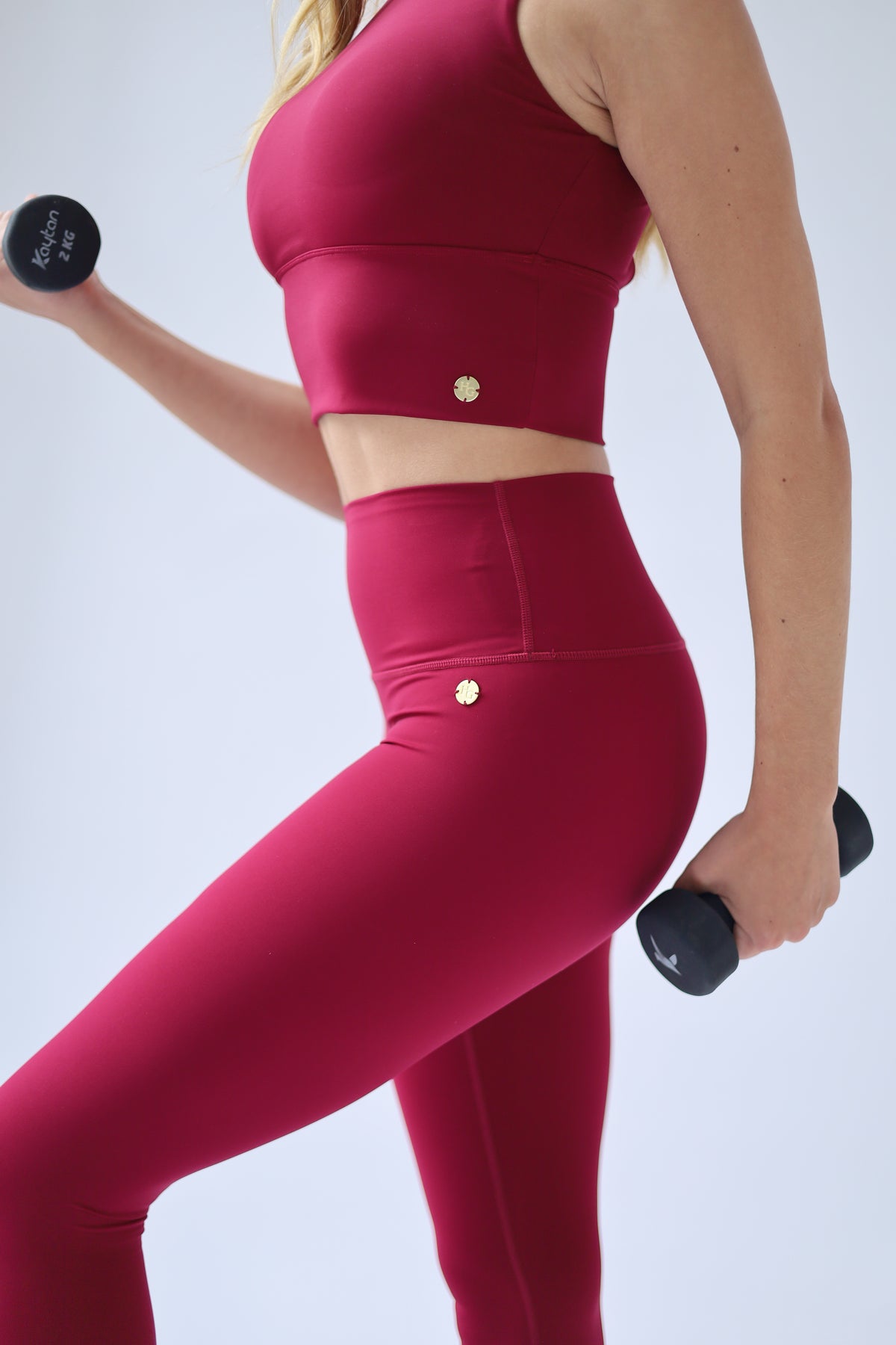 oman wearing a vibrant Deep Ruby Red activewear set on a clean white background, embodying confidence, elegance, and an elevated active lifestyle.