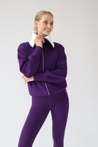 House of Gravity Turtleneck Zip Cardigan in Plum, front view styled with matching leggings, featuring the oversized light grey collar, gold-tone zipper, and tonal HG logo.