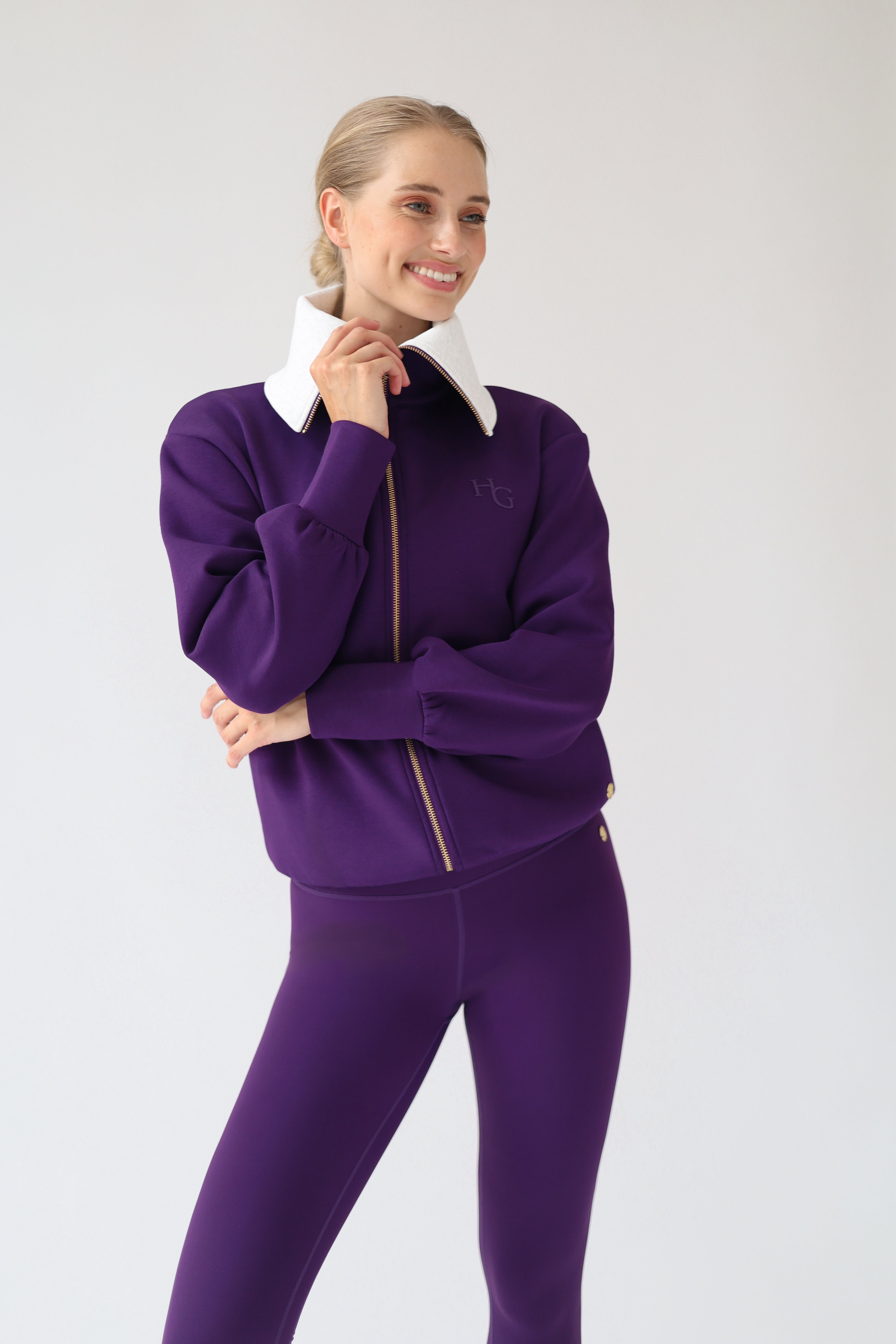 House of Gravity Turtleneck Zip Cardigan in Plum, front view styled with matching leggings, featuring the oversized light grey collar, gold-tone zipper, and tonal HG logo.