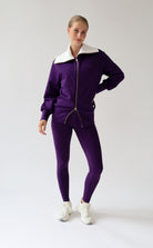 House of Gravity Turtleneck Zip Cardigan in Plum, three-quarter front view featuring the oversized light grey collar, gold-tone zipper, tonal HG logo detail, and matching Plum leggings.