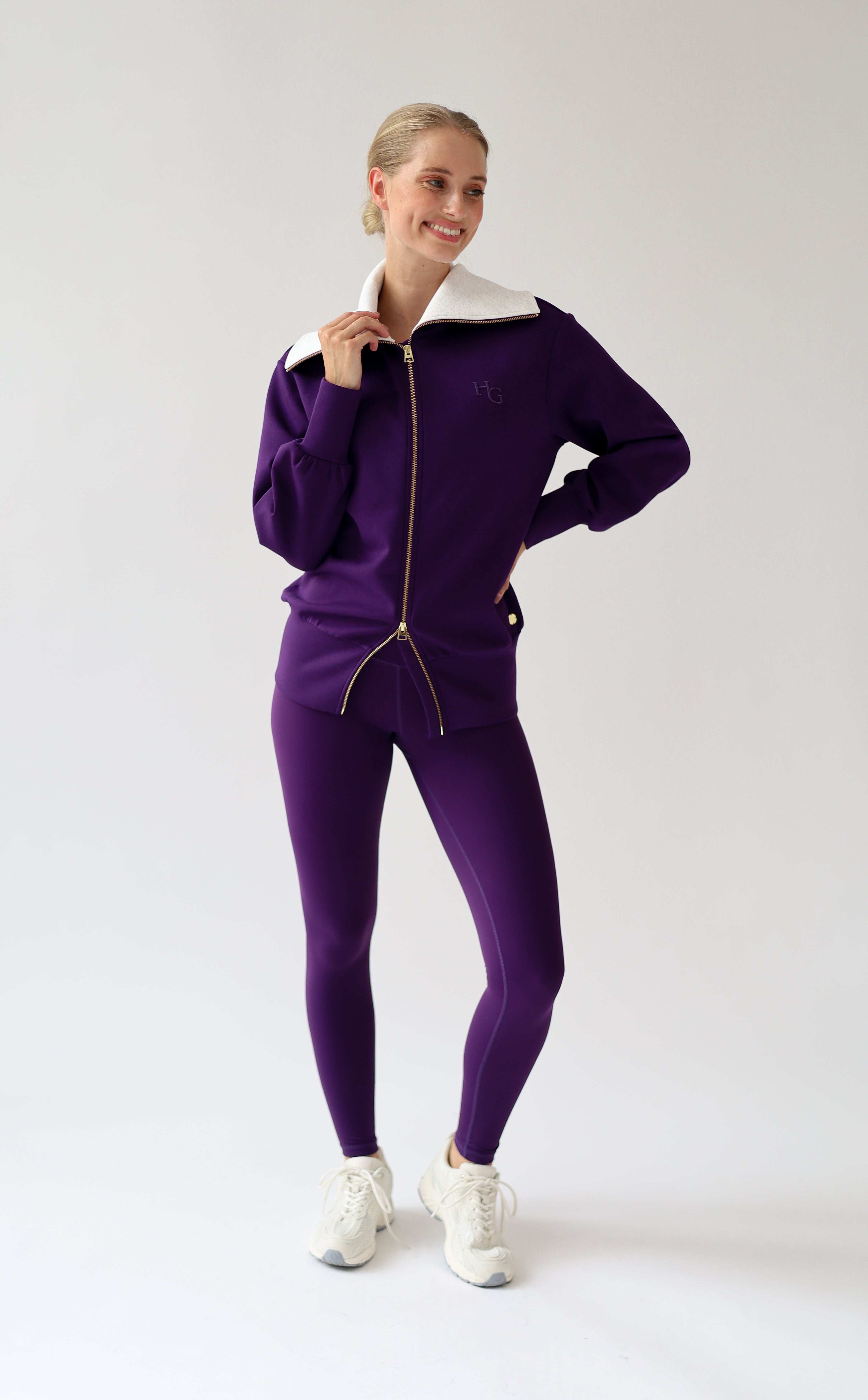 House of Gravity Turtleneck Zip Cardigan in Plum, three-quarter front view featuring the oversized light grey collar, gold-tone zipper, tonal HG logo detail, and matching Plum leggings.