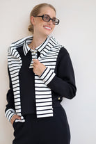 House of Gravity Button Polo Sweater in Black styled with a striped knit draped over the shoulders.