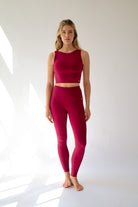 Woman wearing a red athletic outfit on a white background