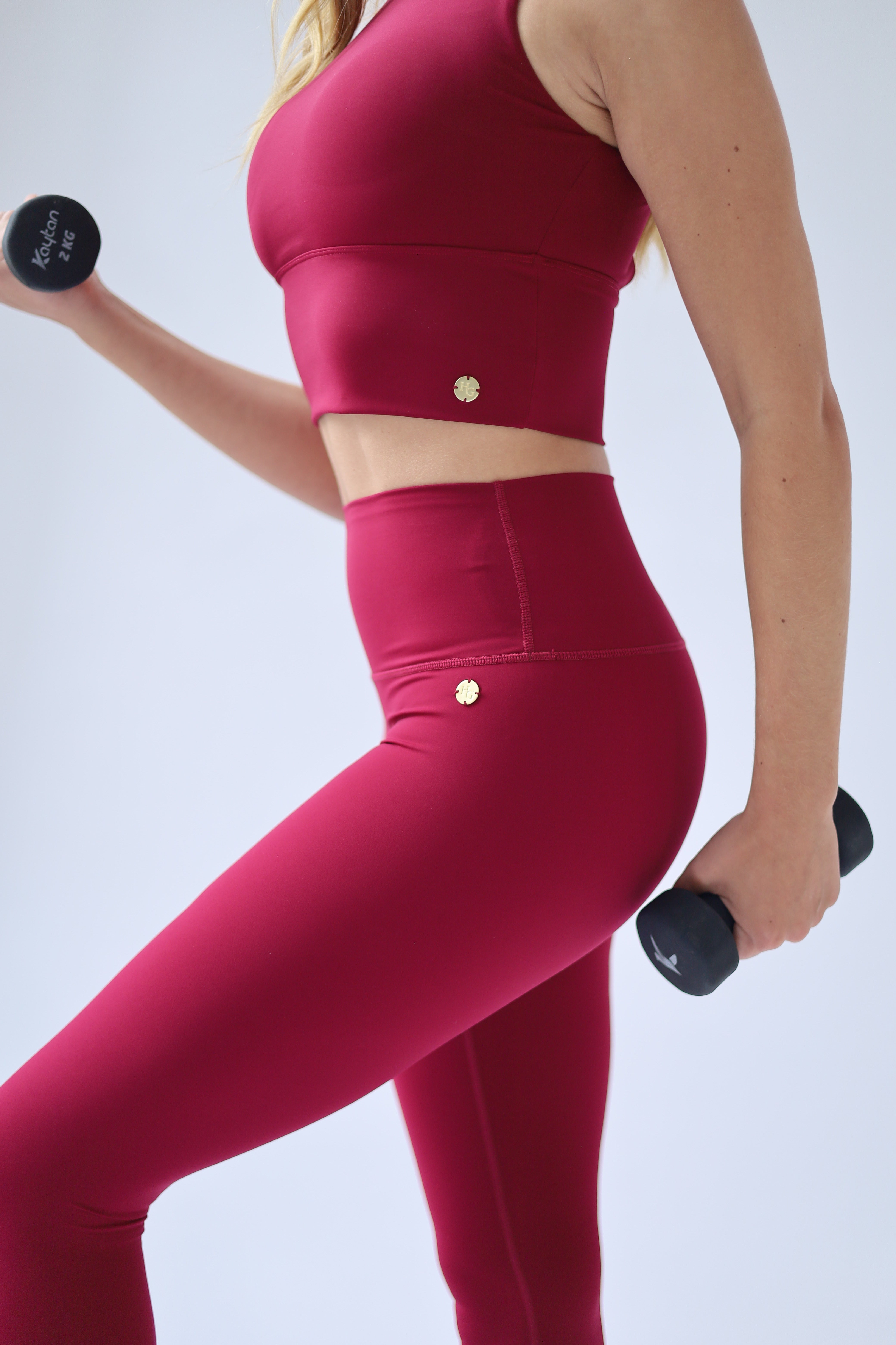 oman wearing a vibrant Deep Ruby Red activewear set on a clean white background, embodying confidence, elegance, and an elevated active lifestyle.