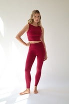 howcasing a sophisticated Deep Ruby Red activewear set, this look blends feminine strength, modern style, and performance-driven comfort against a clean white backdrop.
