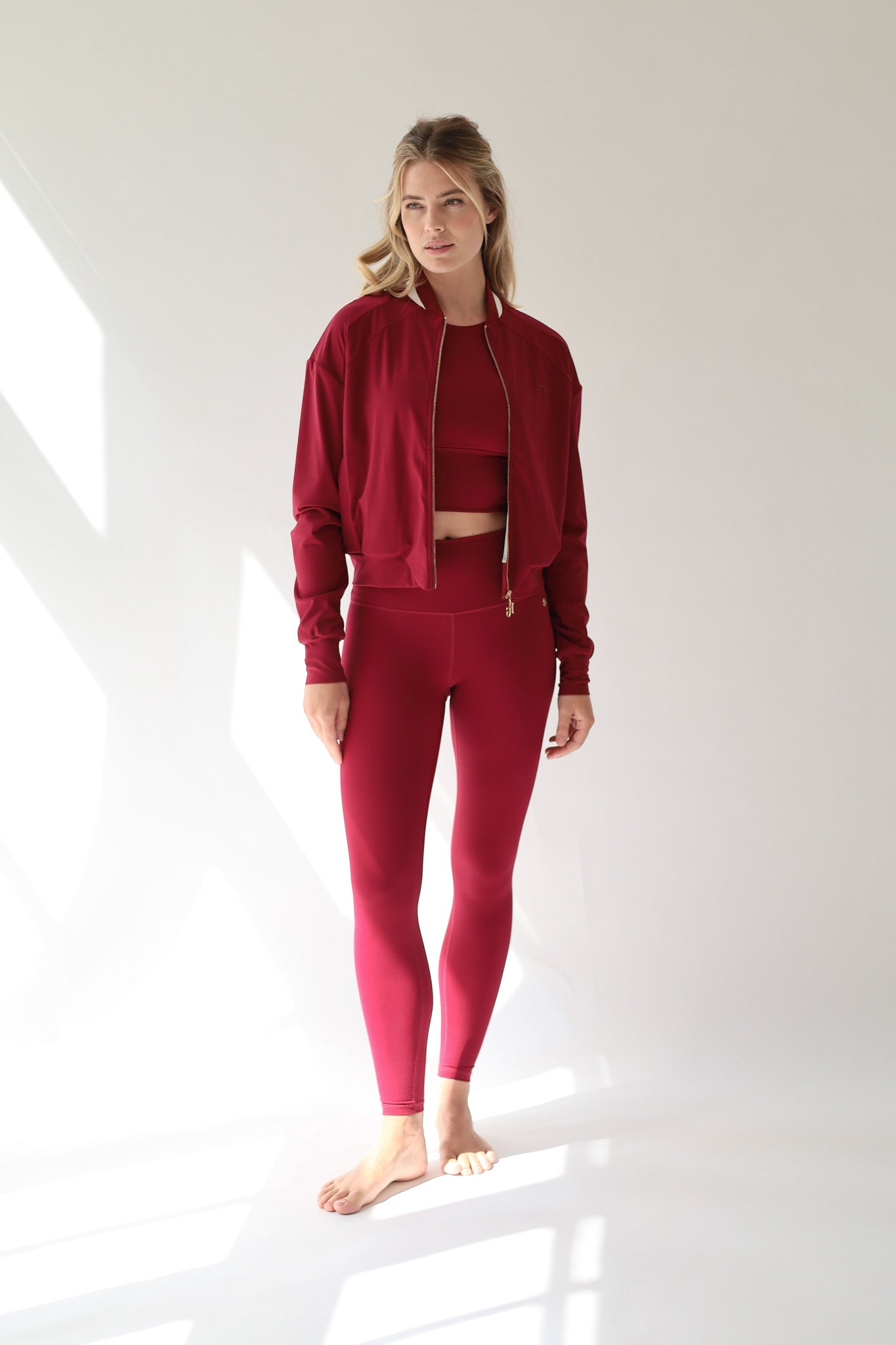 Showcasing a sophisticated Deep Ruby Red activewear set, this look blends feminine strength, modern style, and performance-driven comfort against a clean white backdrop.