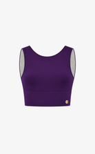 A purple sleeveless crop top with a small gold logo on the bottom left, displayed against a plain white background.